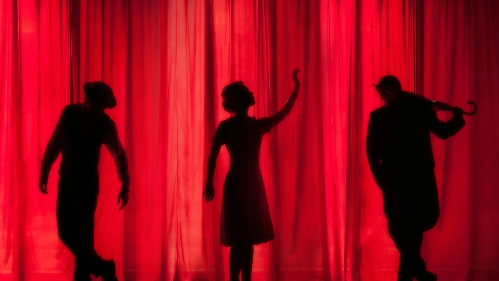 Student actors performing beneath theatrical stage lights